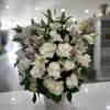  A heartfelt tribute featuring a serene mix of white roses, lilies