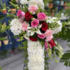 The &ldquo;Cross of Light&rdquo; symbolizes peace and hope, crafted with white flowers