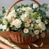 Exquisite floral arrangement in basket, where white roses intertwine with caramel blooms