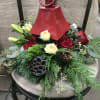 A red lantern with a white candle surrounded by fragrant winter greens