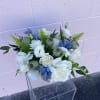This white, blue and green fresh floral arrangement is filled with premium