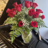 2 dozen roses with greens and babies breath in a vase. 