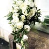 Simple all white roses, lisianthus and greenery creatively arranged to create this