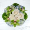 A blue and green arrangement in a stylish silver vase designed with
