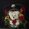 white carnations in the shape of a puppy with other assorted flowers