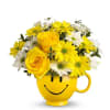 A combination of daises and roses in a smiley face mug