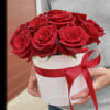 The bouquet consists of bright red roses neatly arranged in a white