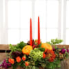 Thanksgiving centerpiece with tapered candles featuring rich fall colors including roses, chrysanthemums