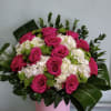Box arrangement with roses, button daisies, and hydrangeas.