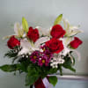 Vase arrangement with roses, daisies, and lilies.