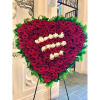 A beautiful heart-shaped standing spray featuring solid red roses. The heart is