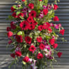 This standing spray includes roses, dendrobium orchis