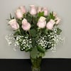 A bouquet of beautiful long stemmed pink roses arranged in a vase