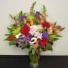 Vase arrangement of assorted flowers in rich fall colours, perfect for the