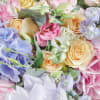 A carefully selected vase arrangement of assorted pastel coloured flowers, chosen uniquely