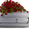 The deep red flowers of this red rose casket spray speak to