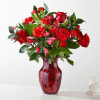 Amplified by a ruby red vase, this rich arrangement of roses, carnations