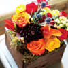 Wooden box fill with seasonal flowers combination .
Very popular floral arrangement with
