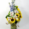 Unique arrangement of Sunflowers, orchids, greenery and mix floral to complement the