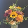 A fresh bouquet of sunflowers, disbuds, carnation, rose, wax flowers and mix