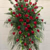 red flower arrangement on stand with red roses