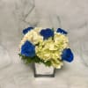 This blue and white arrangement is designed in a gorgeous silver cube