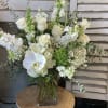 Standing tall and lushly filled with all white roses, hydrangea, flowing eucalyptus