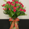 Rich and luscious red mini carnations surrounded by winter greenery, wrapped in