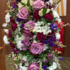 Lavender standing spray including lavender roses and other blooms as available. 