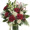 Red roses, creme roses and white snapdragons are wrapped in a variegated
