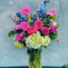 Colorful blooms designed in heighten vase. 

Hydrangeas, Gerber daises, roses , delphiniums