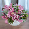 This elegant arrangement features exquisite pink cymbidium orchids complemented by lush greenery