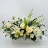 A beautiful arrangement of all white flowers to include lilies, hydrangea, stock