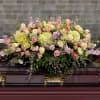 Soft colors, large cover casket arrangement.
