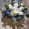 A mixture of blue and white blooms, roses, hydrangeas, thistle and much