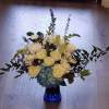 A mixture of blue and white blooms, roses, hydrangeas, thistle and much