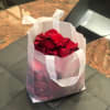 AN 8X10X4 INCH CLEAR FROSTED BAG FULL OF RED ROSE PETALS