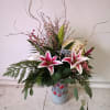 Festive Christas ornaments vase with varied Christmas greens, stargazer Lily, white hydrangea