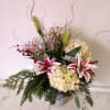 Festive Christas ornaments vase with varied Christmas greens, stargazer Lily, white hydrangea