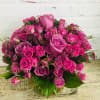 Vibrant arrangement of roses and spray roses in a bubble bowl laced