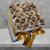 A modern flower arrangement in a white box filled with gold painted