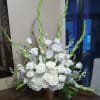 An all white tribute, this funeral basket is pure and tranquil. Featuring