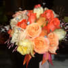 A BRIDAL BOUQUET IN ORANGE HUES, ACCENTED WITH RHINESTONE GEMS.