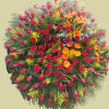 A standing wreath adorned with red, orange, and blue flowers exudes a