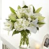Classic lilies and hydrangea blooms in a clear vase offer comfort and
