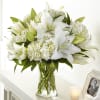 Classic lilies and hydrangea blooms in a clear vase offer comfort and