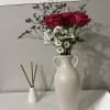 A cluster of Roses arranged in a small vase. This petite display