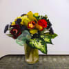 Fresh floral arrangement with roses, orchids, chrysanthemums, and tropical foliage. We deliver.