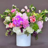 This elegant and posh garden arrangement sits regally in a beautiful white