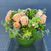 A darling arrangement with amazing taupe and peach roses in a leaf-lined